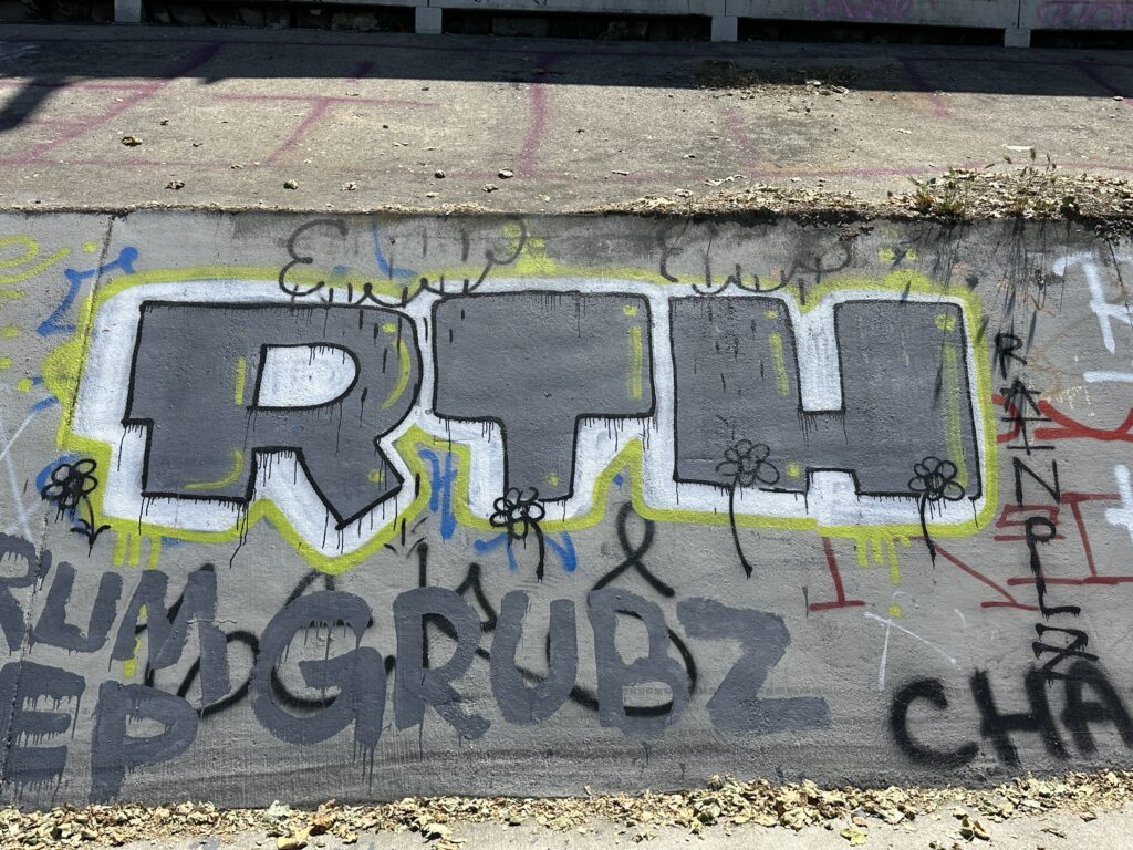 Graffiti tag: RTH. Gray, white, and yellow